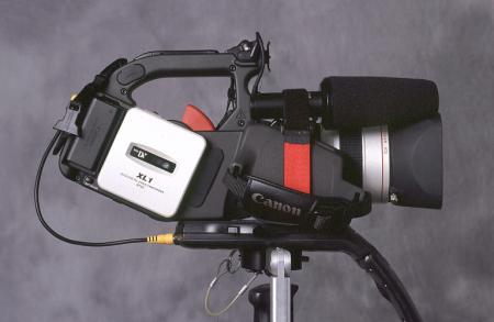 XL1 parked on display stand with microphone attached to right side of camera with Velcro cinch strap.